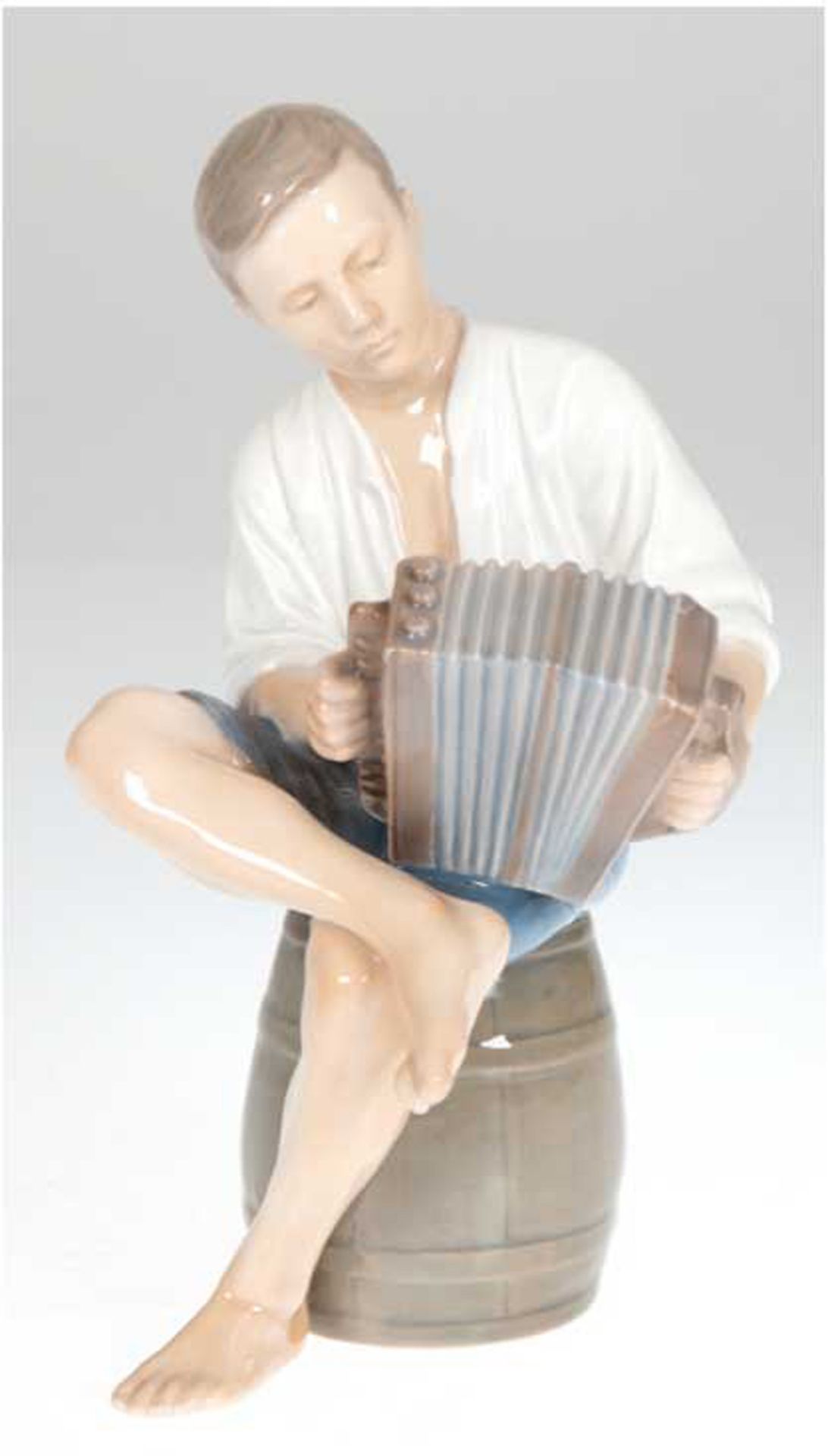 Porzellanfigur "Ziehharmonikaspieler auf Faß sitzend", Bing & Gröndahl, Nr. 1661, polychrom bemalt,