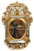 Spiegel, 19.Jh., Holz, floral durchbrochen geschnitzt und gold gefaßt, ovales Spiegelfeld mit 4-sei