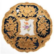 Meissen-Prunkteller, im Spiegel polychrome Blumenmalerei, kobaltblaue Fahne mit vergoldetem reliefi