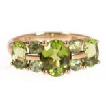 Ring, England, 9 kt GG, besetzt mit 7 oval, facettiertem Peridot in einer Reihe, in Krappenfassung,