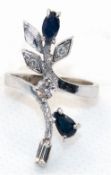Ring, 750er WG, florales Design, besetzt mit 3 Brillanten, 1 Baguette-Diamant und 2 Saphiren, ges. 