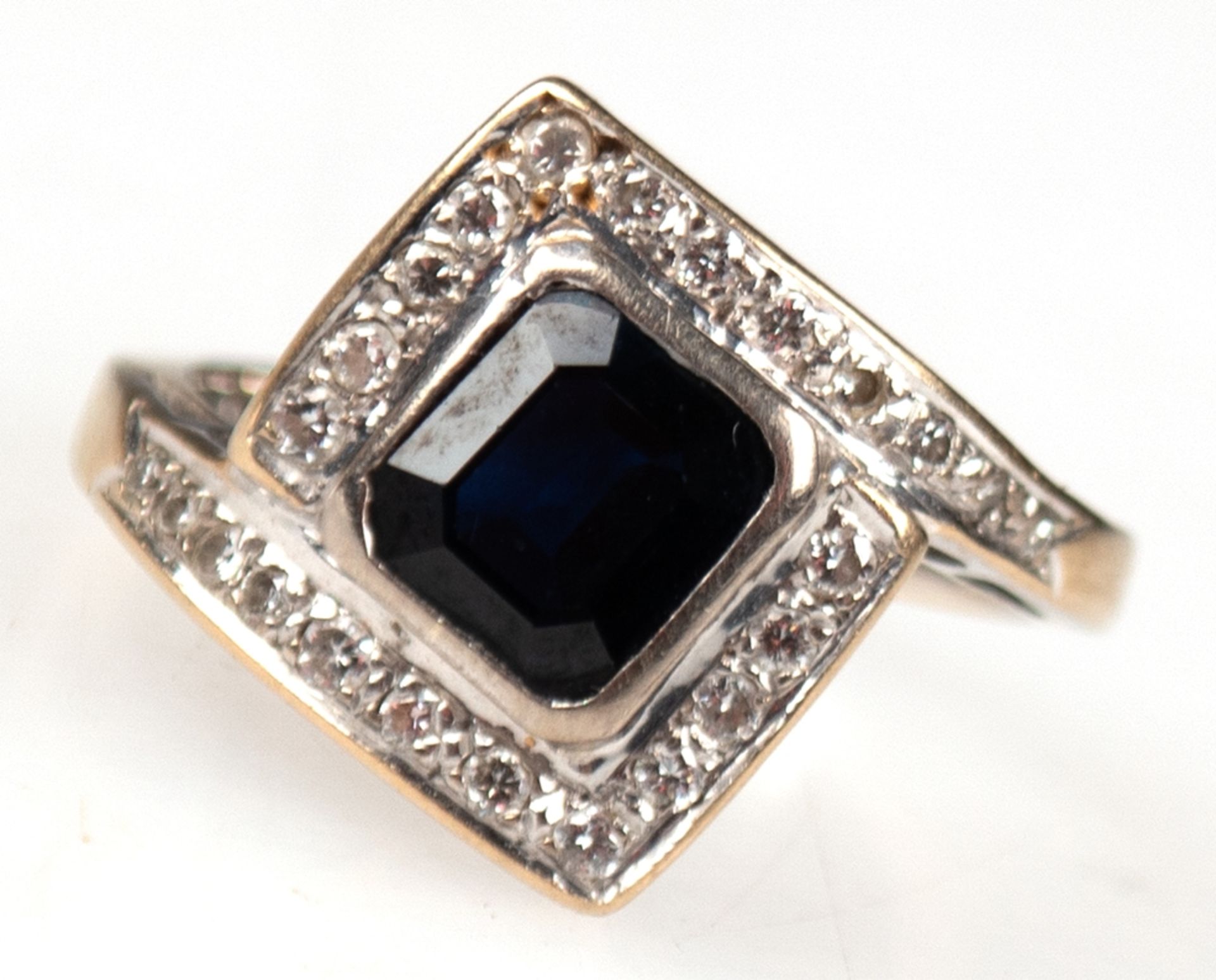 Ring, 750er WG, Ringschiene in rhombenförmigen Ringkopf mit Diamantbesatz übergehend, mittig facett