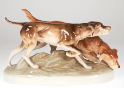 Figurengruppe "Zwei Jagdhunde", Royal Dux, polychrom bemalt, auf naturalistischem, ovalem Sockel, 2