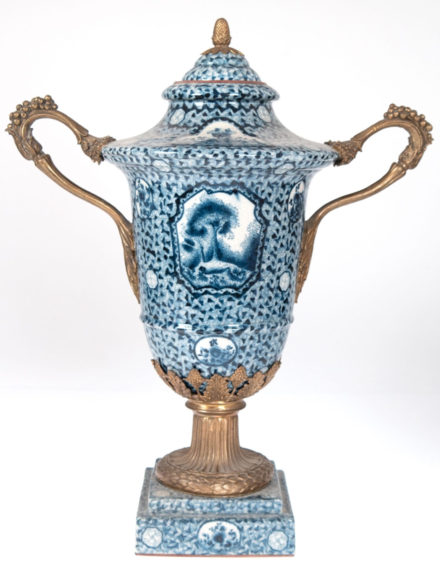 Deckel-Vase, Keramik mit Bronzebesatz, vollflächiger Blaudekor, auf quadratischem Sockel reliefiert