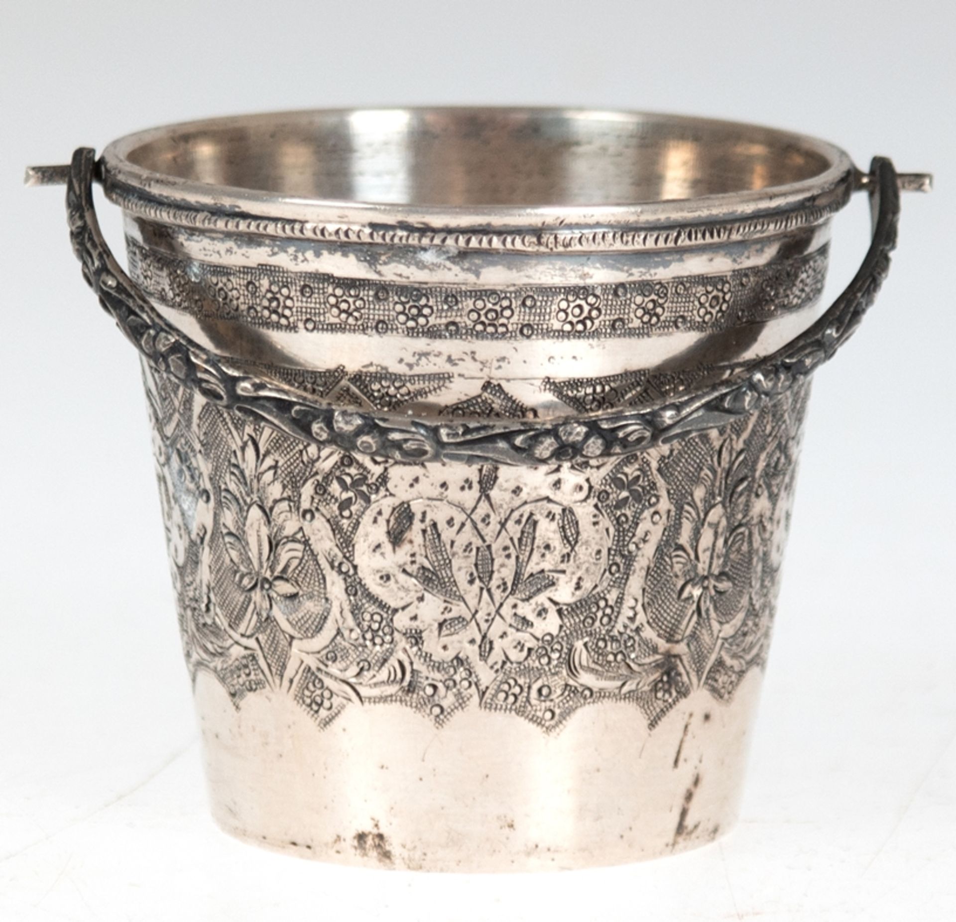 Becher, Rußland, 84 Zol. Silber, in Form eines Eimers mit floral reliefiertem Klapphenkel, umlaufen