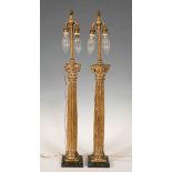 Pair of lamps, after 17th century models; early 20th century.Gilded wood, brass and marble base.