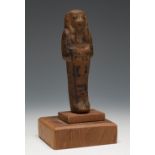 Ushebti; Egypt, New Kingdom, c. 1550 - 1070 BC.Brown faience. Wooden base.Enclosed photocopy of