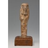 Ushebti; Egypt, Lower Egypt, Ptolemaic period, 2nd-1st century BC.Brown faience. Wooden base.