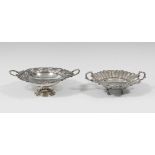 Two silver centrepieces. One of them has a circular base with a raised base and a band of