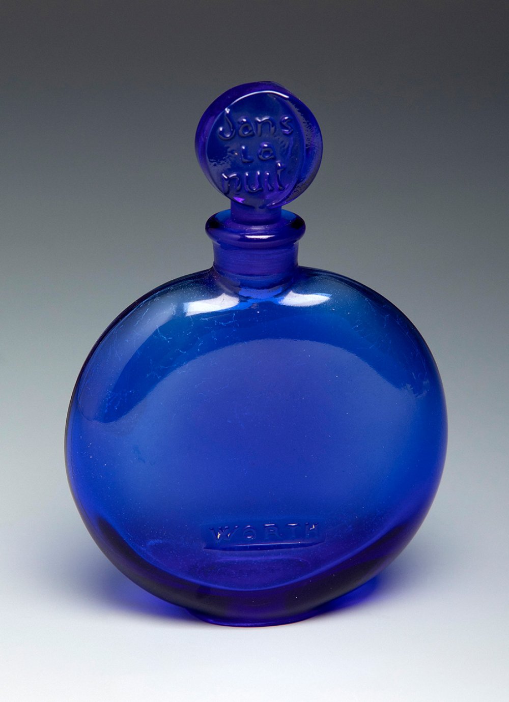 Worth "Dans la Nuit" fragrance bottle, ca. 1980.Blue moulded glass.Marks on the reverse of the