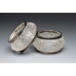 Set of two Art Deco napkin rings; France, circa 1940.Moulded glass and metal.Damage to the glass.