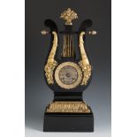 Empire lyre clock. France, early 19th century.Wooden structure with gilt bronze details.In need of