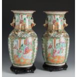 Pair of Chinese Canton vases, late 19th century.Enamelled porcelain.Size: 34 x 18 x 18 cm (vases); 4