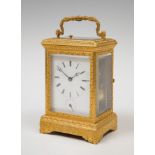 Travel clock; late 19th century.Bronze and bevelled glass.No key.Original case.Measurements: 18 x 11