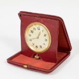 Travel alarm clock; 20th century.Red leather case.Measurements: 10 x 10,5 cm.Travel alarm clock made