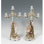 German work, following Saxon models, 19th century.Pair of candlesticks.Enamelled porcelain.With