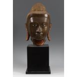 Buddha head. Burma, 17th-18th century.Bronze.Measurements: 43 x 25 x 30 cm.; 68 cm. high with