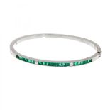 Rigid bracelet, slave type, in 18kt white gold. Frontis with a line of princess-cut emeralds,