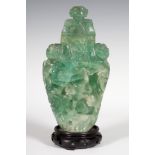 Vase. China, early 20th century.Jadeite with carved wooden stand.Measurements: 22 x 12.5 x 9 cm;