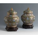 Pair of ginger storage jars. China, 1920-1940.Bronze and cloisonné enamel. Carved wooden bases.