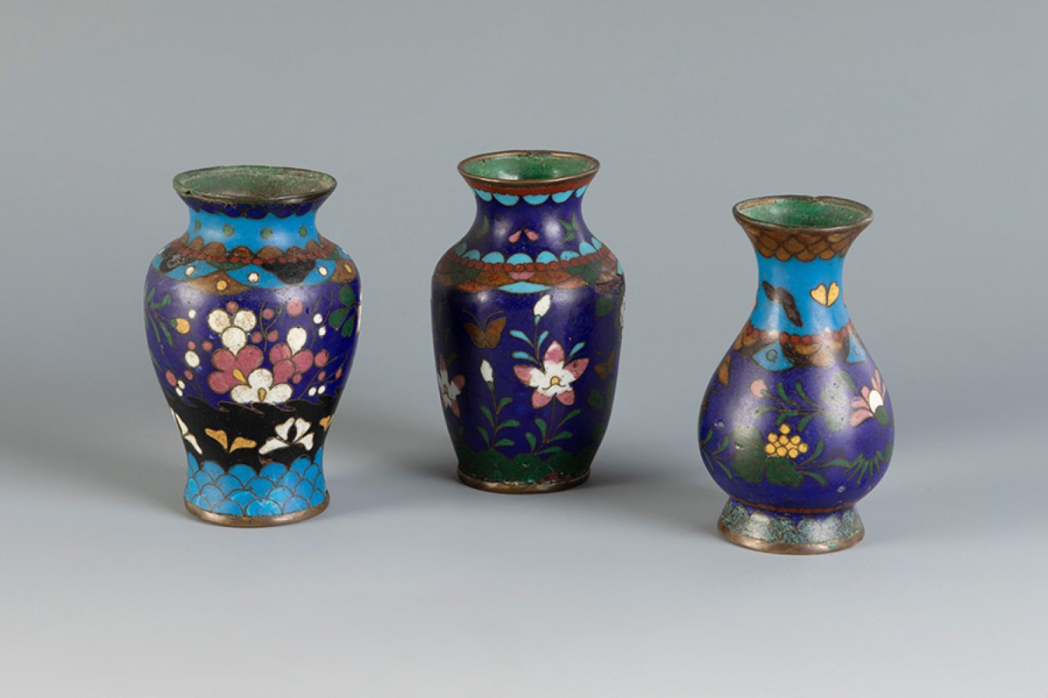 Set of three vases. Japan, Edo period, 19th century.Bronze and cloisonné enamel.With marks of use.