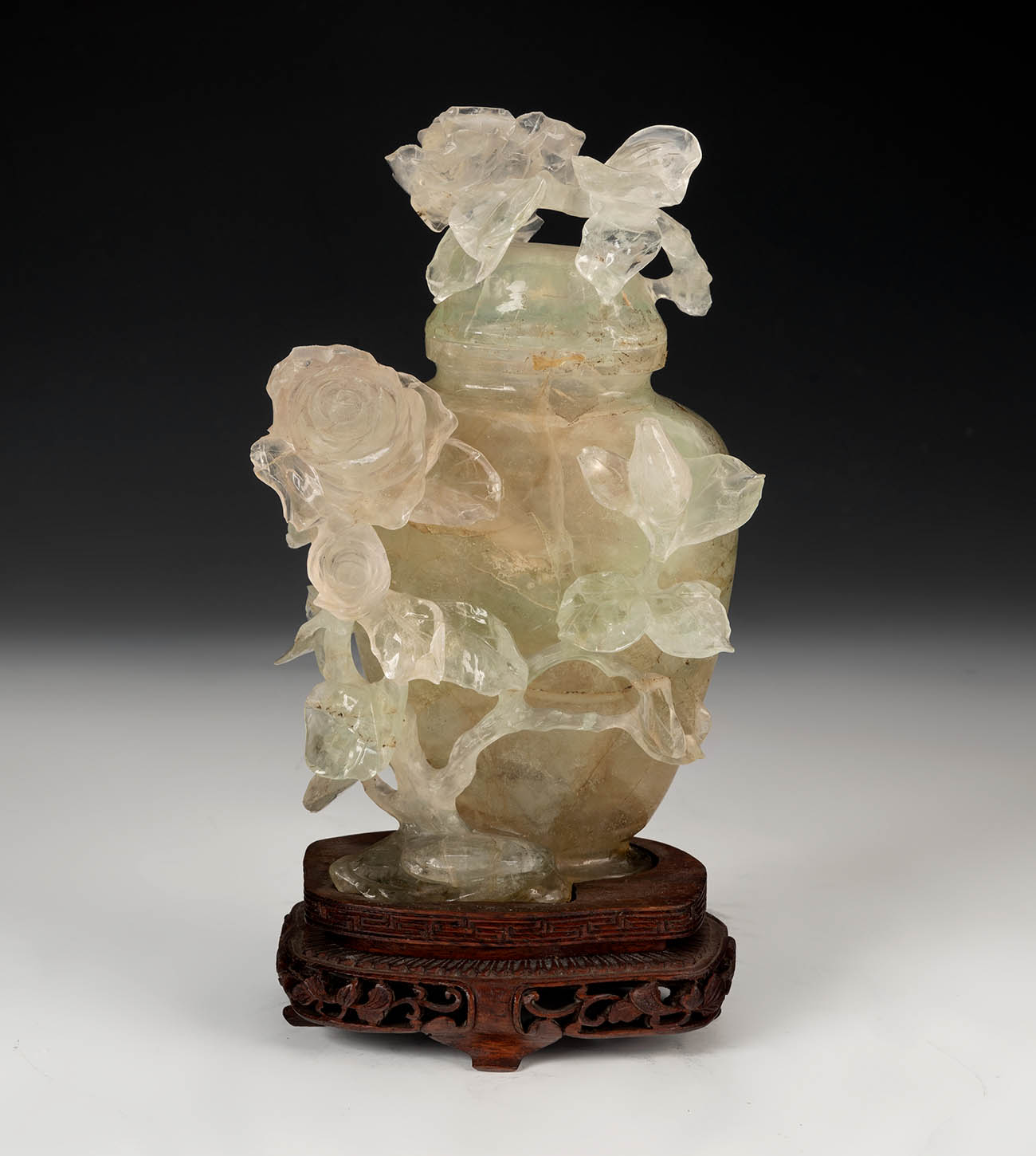 Potiche with flowers. China, 20th century.Hand carved fluorite on wooden base.Size: 16 cm (