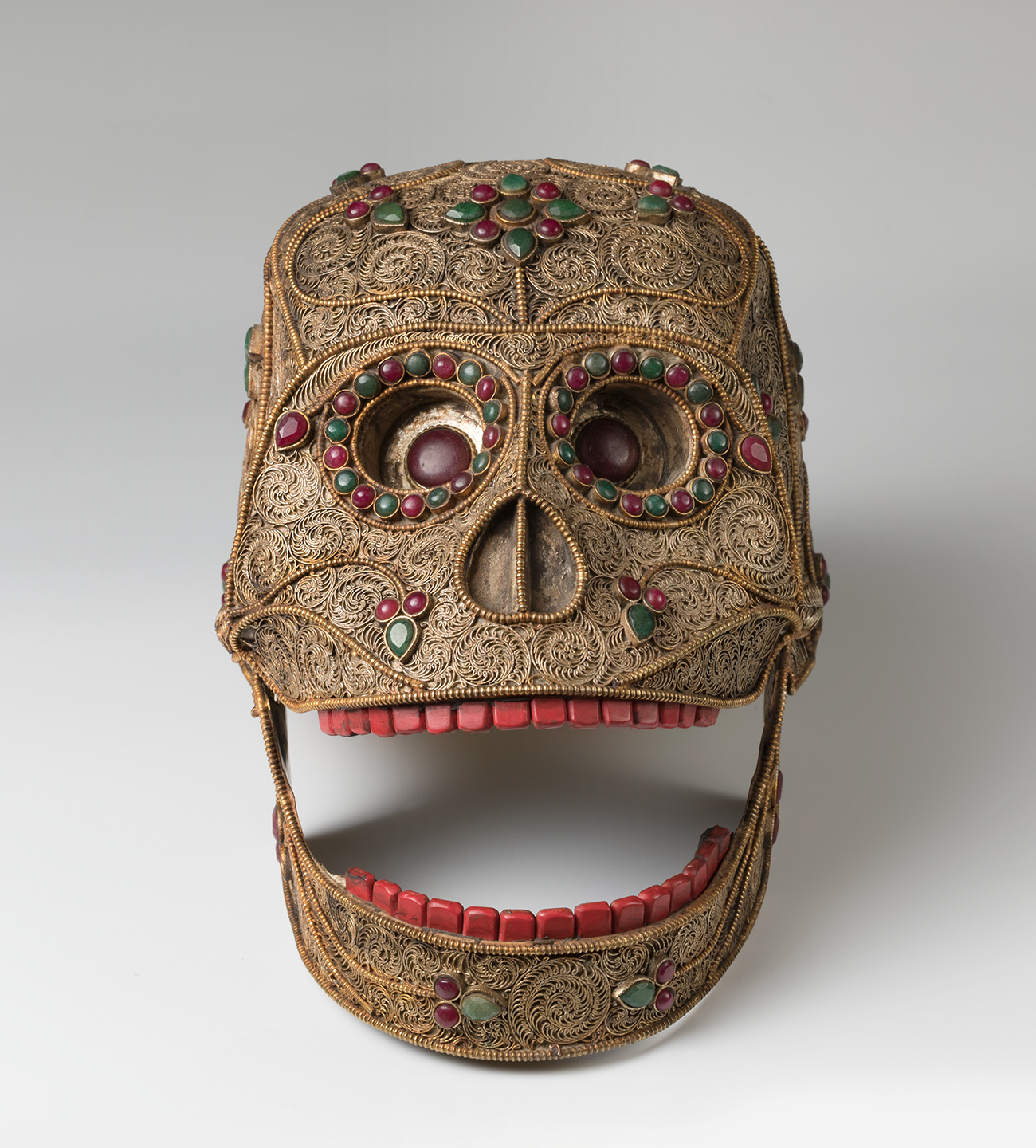 Mexican school; circa 1800."Skull.Silver alloy with garnets, emeralds and hard coloured stones.