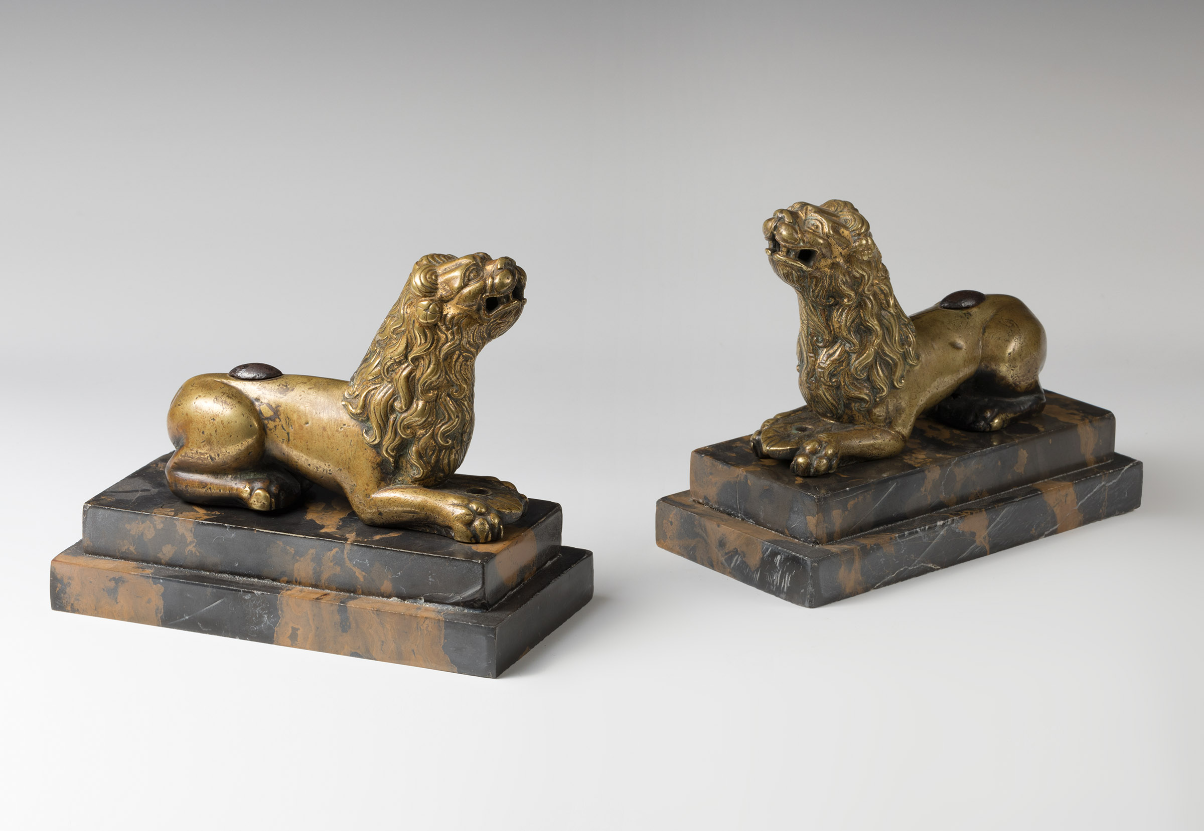 Italian work; circa 1500."Pair of lions.Gilded bronze.Presents iron reeds.Measurements. 10 x 14 x
