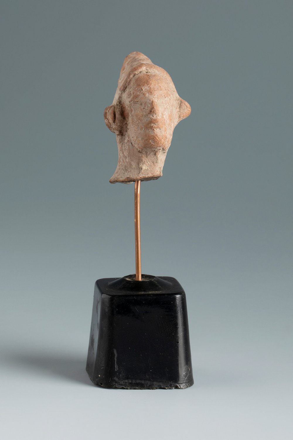 Grotesque head with Phrygian cap. Smyrna, 3rd century BC.Terracotta.Provenance: Smyrna, 1895-1905.