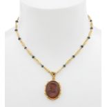Necklace and pendant in 18kt yellow gold. Link chain in 18kt yellow gold with blue stone bead