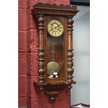 A Victorian Vienna wallclock, enamelled dial, Roman numerals flanked by turned pilasters.