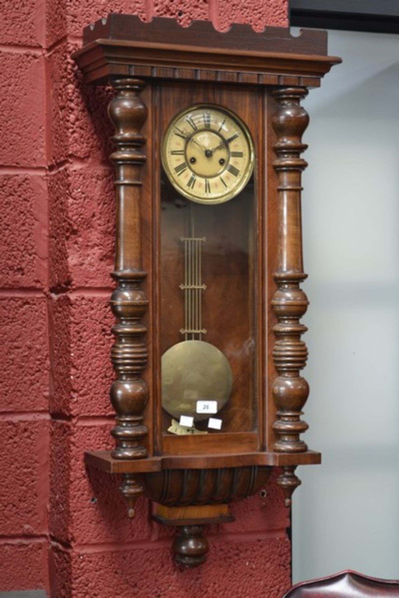 A Victorian Vienna wallclock, enamelled dial, Roman numerals flanked by turned pilasters.