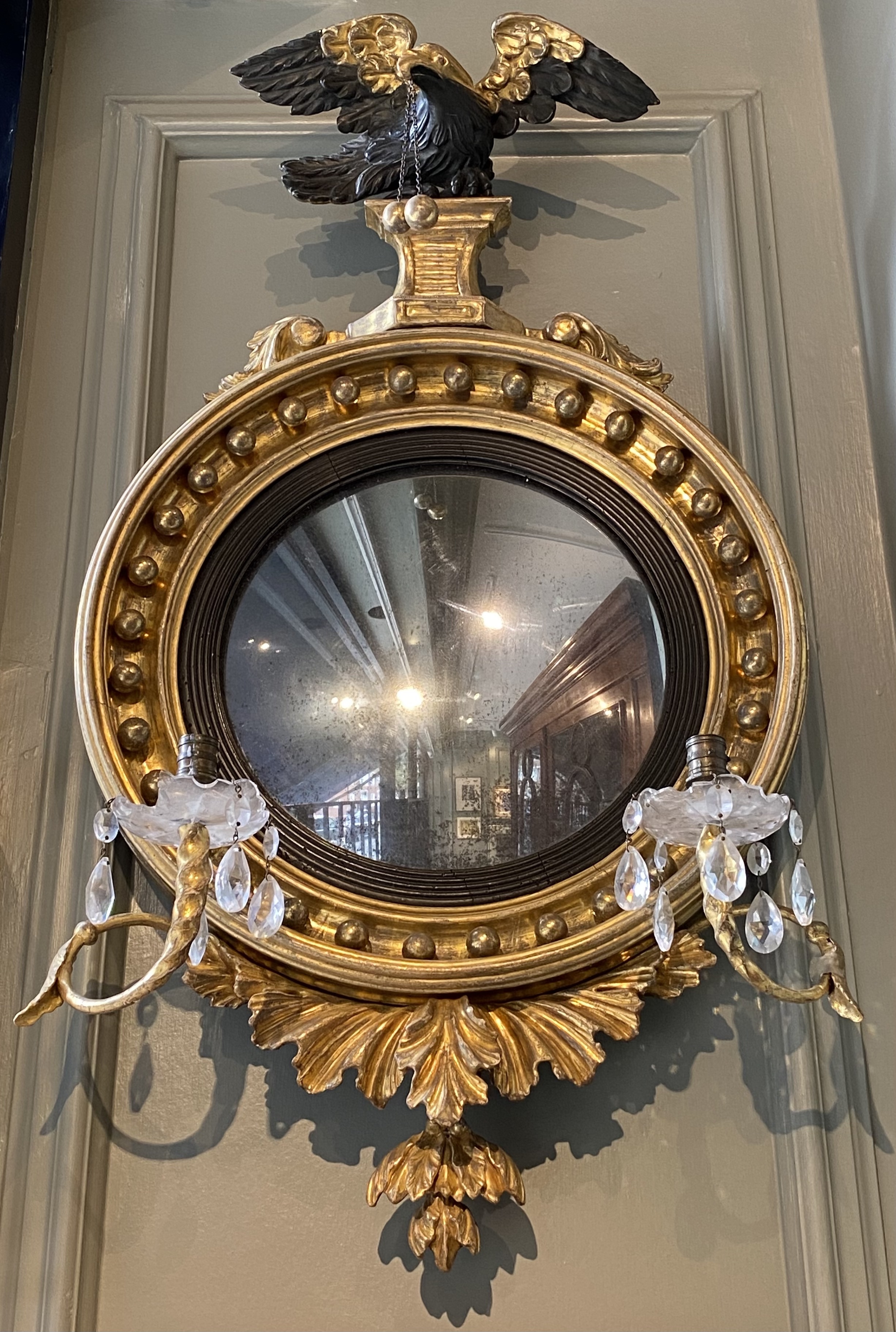 A Regency giltwood convex mirror with crystal sconces