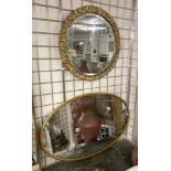 A GILT OVAL MIRROR WITH A GILT CIRCLE MIRROR