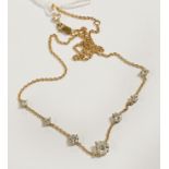 AN 18CT (MARKED 750) GOLD NECKLACE SET WITH 8 GRADUATED DIAMONDS THE LARGEST 0.75 POINTS