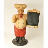 A resin statue of a baker holding a menu board, 49cm tall.