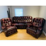 A three seater button back sofa, wine red, with metal stud decoration, scroll arms, 210cm x 95cm x