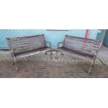 A pair of carst brown painted and hardwood slat garden benches, with lion mask arms, 127cm