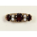 A 9ct gold garnet and cultured pearl three stone ring, carved claw set, M 1/2, 2.7gm