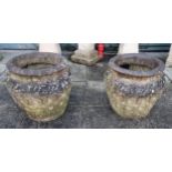 A pair of Cotswold stone garden urns with typical decoration, 40cm