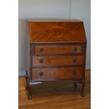A mahogany bureau, with inlayed decoration, hinged door to reveal a fitted interior, with green