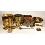 A collection of brass and copper wares to include a coal helmet, mixing bowl, pair of candle sticks,