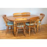 An extending stained pine dining table, turned legs, with a set of six matching dining chairs, uphol