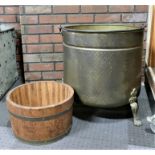 A substantial brass peat coal bucket, hand beaten brass with steel handle, seated on three cast