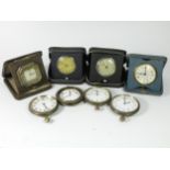 A collection of 1920s/30s eight day bedside travel clocks, together with mid Century mantle clock