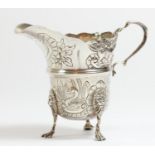 An Irish silver cream jug, by Wakely & Weaver, Dublin 1921, of traditional Irish form, embossed with