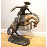 After Frederick Remmington, bronco buster a bronze group, modelled as a cowboy on a rearing horse,