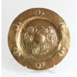 An Arts and Crafts brass platter, probably Scottish school, embossed with thistles, 28.5cm