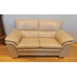 A modern leather two seater sofa, beige in colour. L160cm, H87cm.