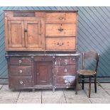 A Victorian pitch pine dresser base comprising of central cupboard, flanked by three drawers